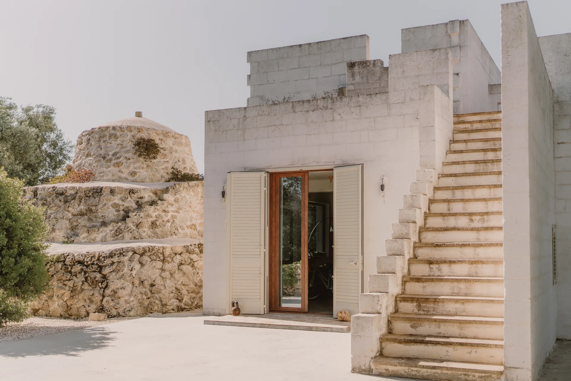 The white stone house beside the old trullo, with the outside stair to the roof