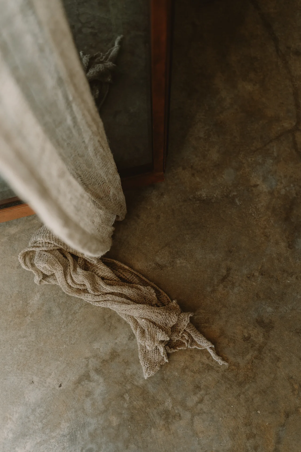 A linen curtain resting on the floor