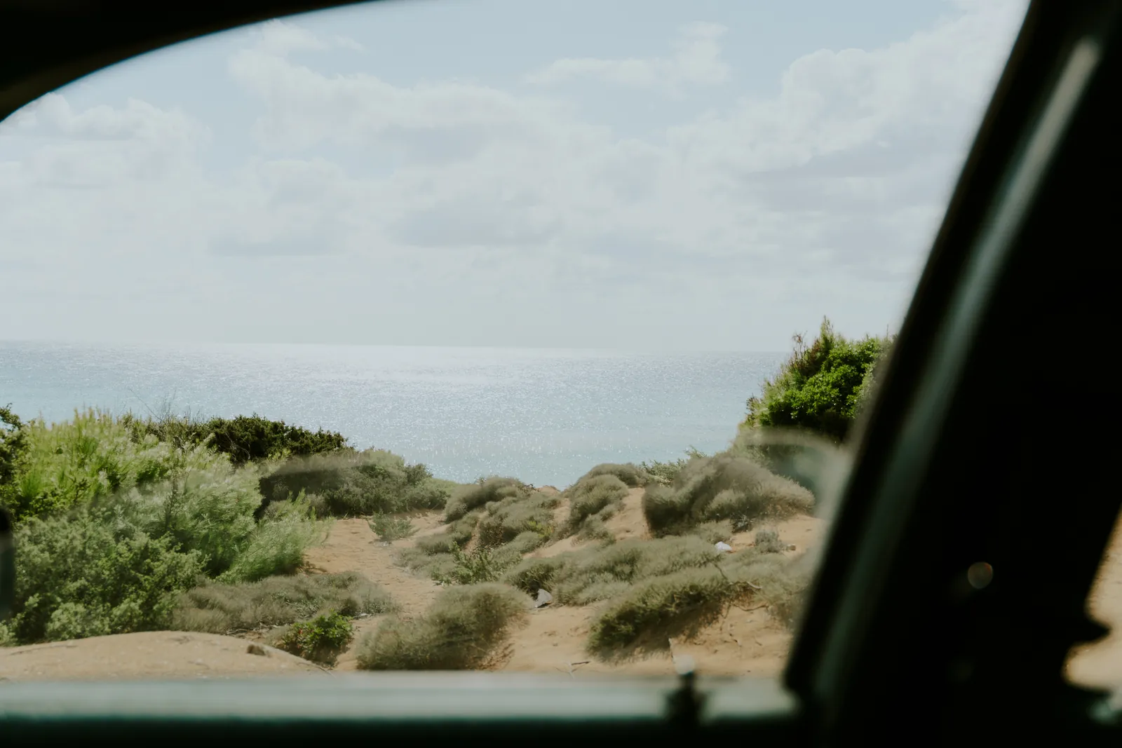 The dunes and the sea seen through a car window