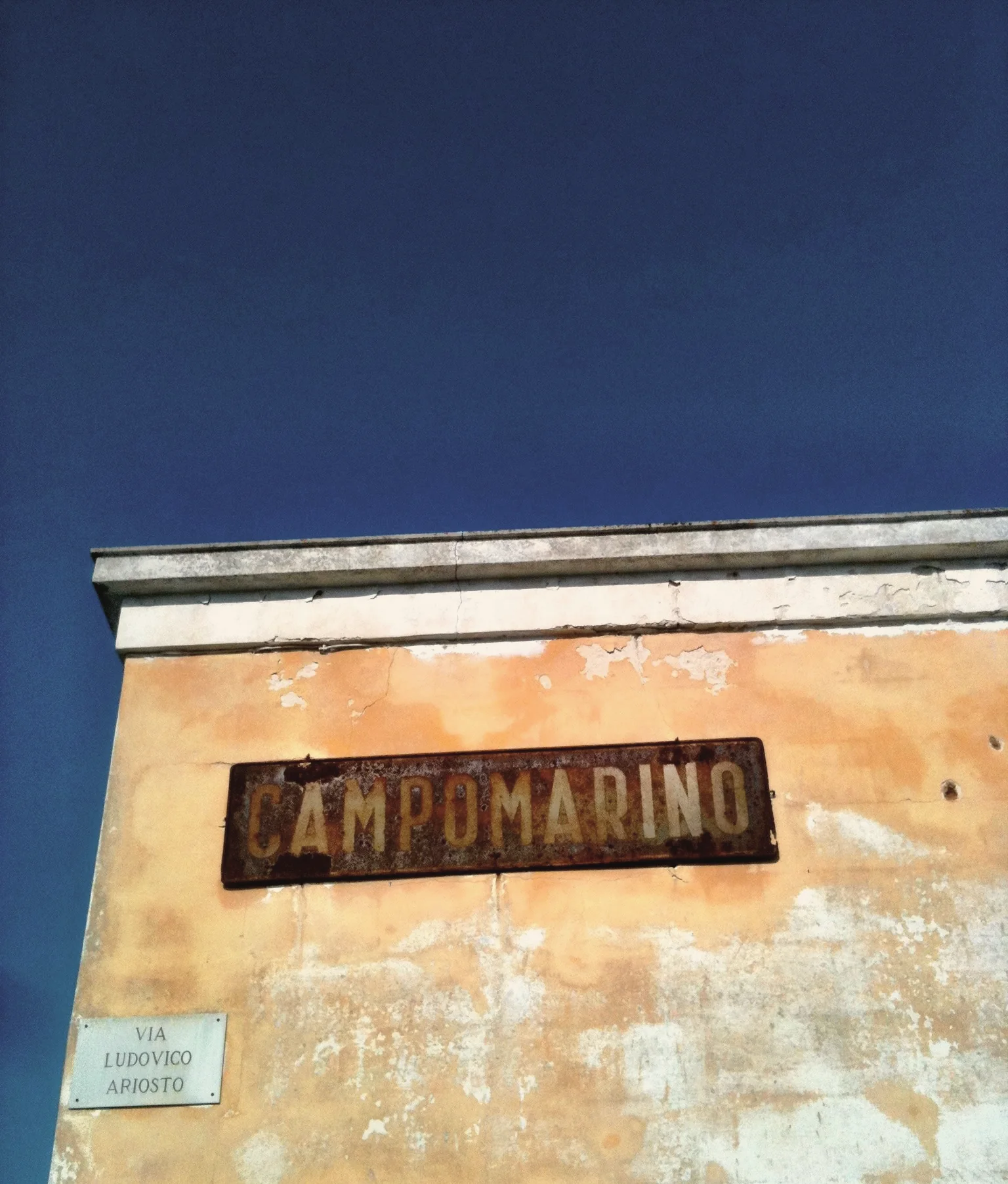 The old Campomarino sign on a weathered wall under a blue sky
