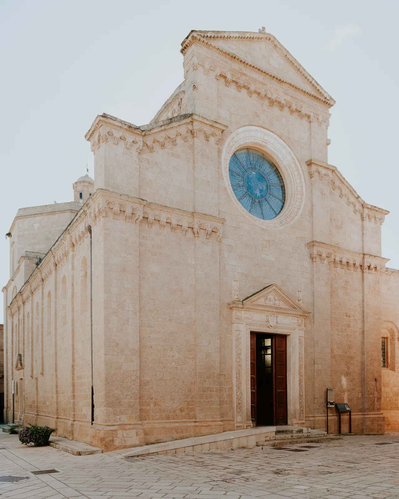The white façade and rose window of Maruggio’s mother church