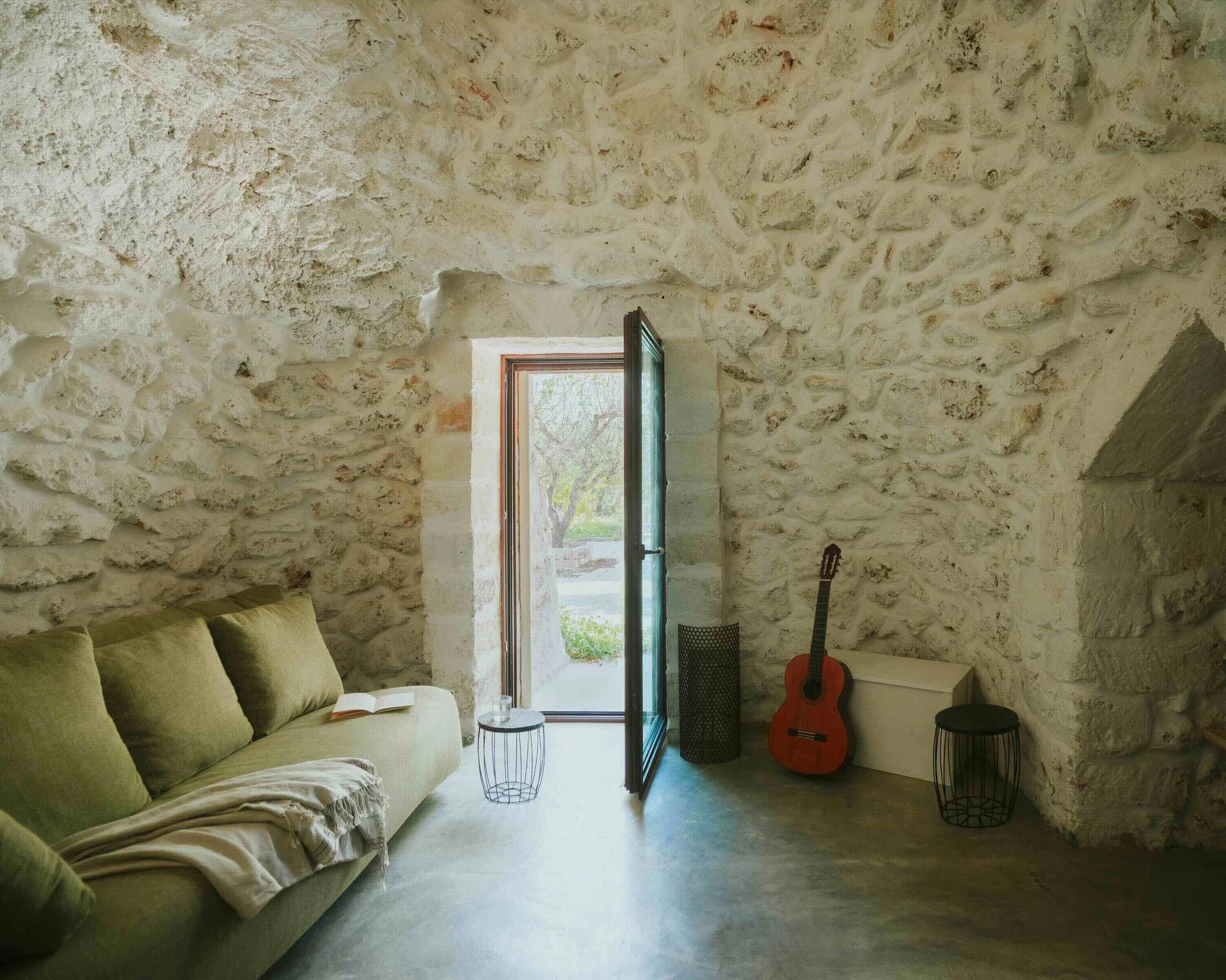 The second bedroom, inside the trullo: stone walls and a door onto the garden