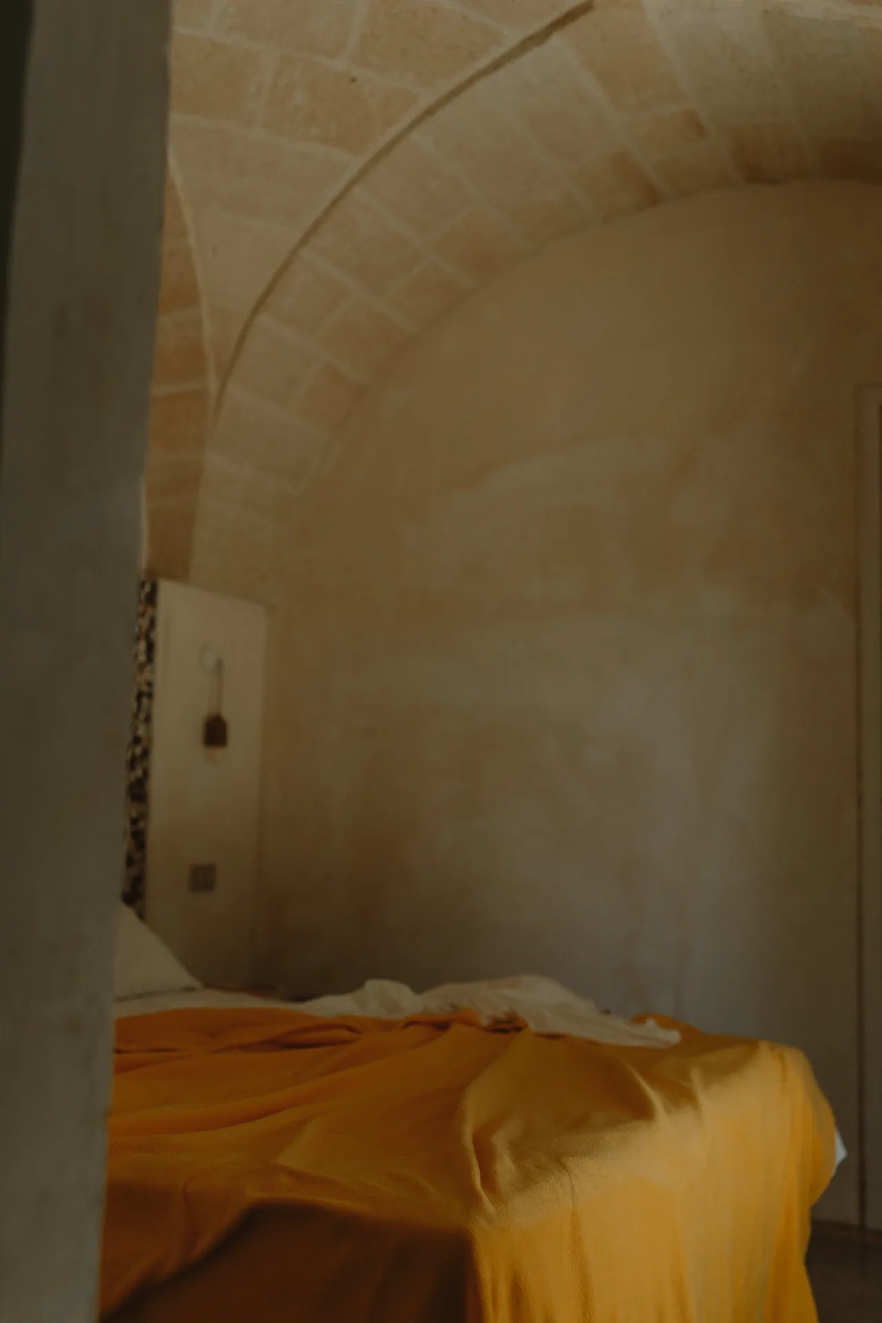 A yellow blanket on the bed beneath the vault